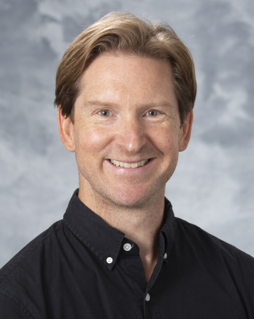 Lucas Richert's profile picture: a white man with light hair in a black button-up smiling against a light grey background.