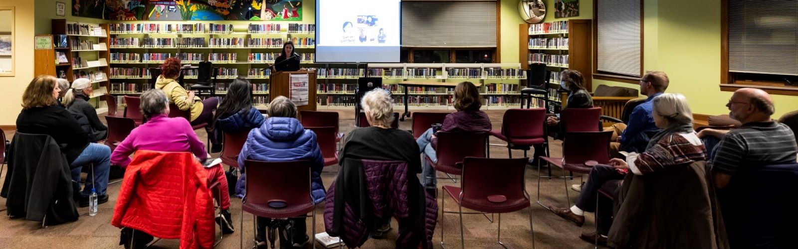 Speaker Lori Kido Lopez speaks in front of an audience at a library.