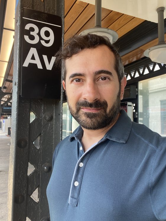 Henrique Nardi's profile picture. A Brazilian man with dark hair and a blue shirt smiles at the camera; behind him is a sign that says 