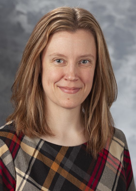 Sandy Peterson's profile picture. A white woman with shoulder-length blonde hair in a plaid top smiles at the camera against a grey background.
